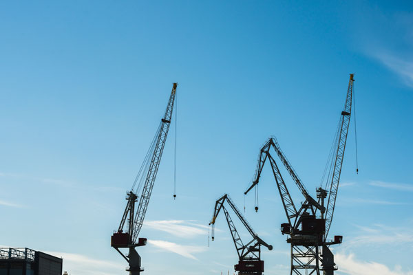 Three cranes used in a construction site