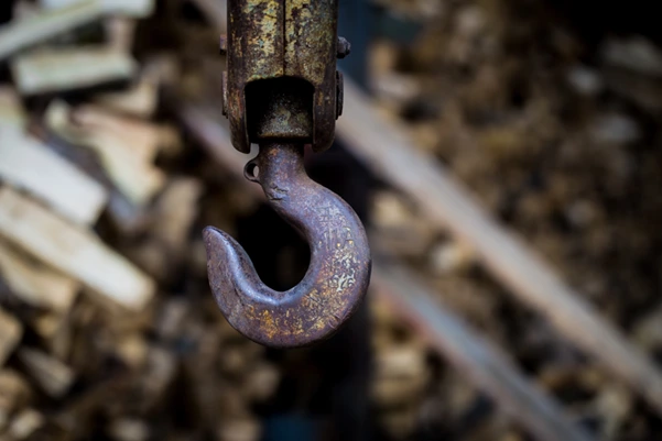 a large, rusty crane hook, clearly showing corrosion which is a sign that the part needs immediate attention or replacement