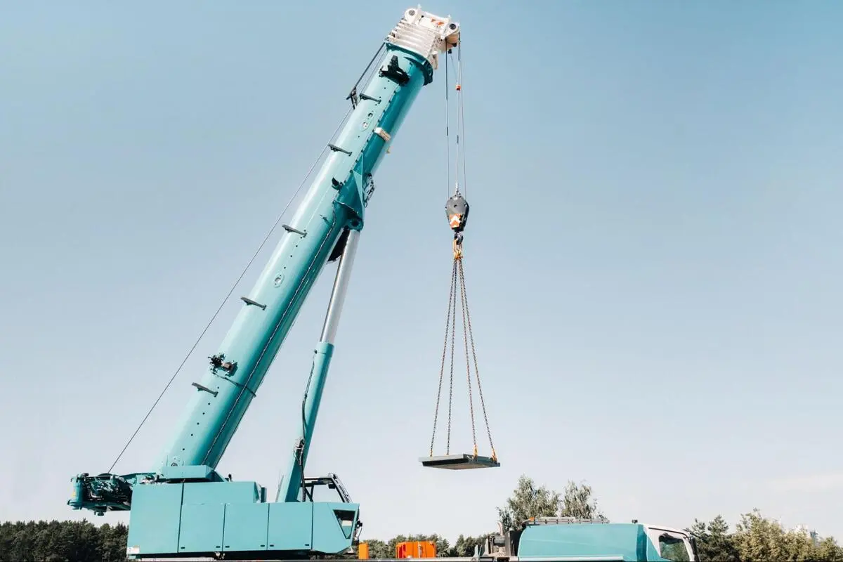 Mobile Crane Lifting Load at Construction Site Mobile crane lifting a heavy flat load with steel cables at an outdoor construction site