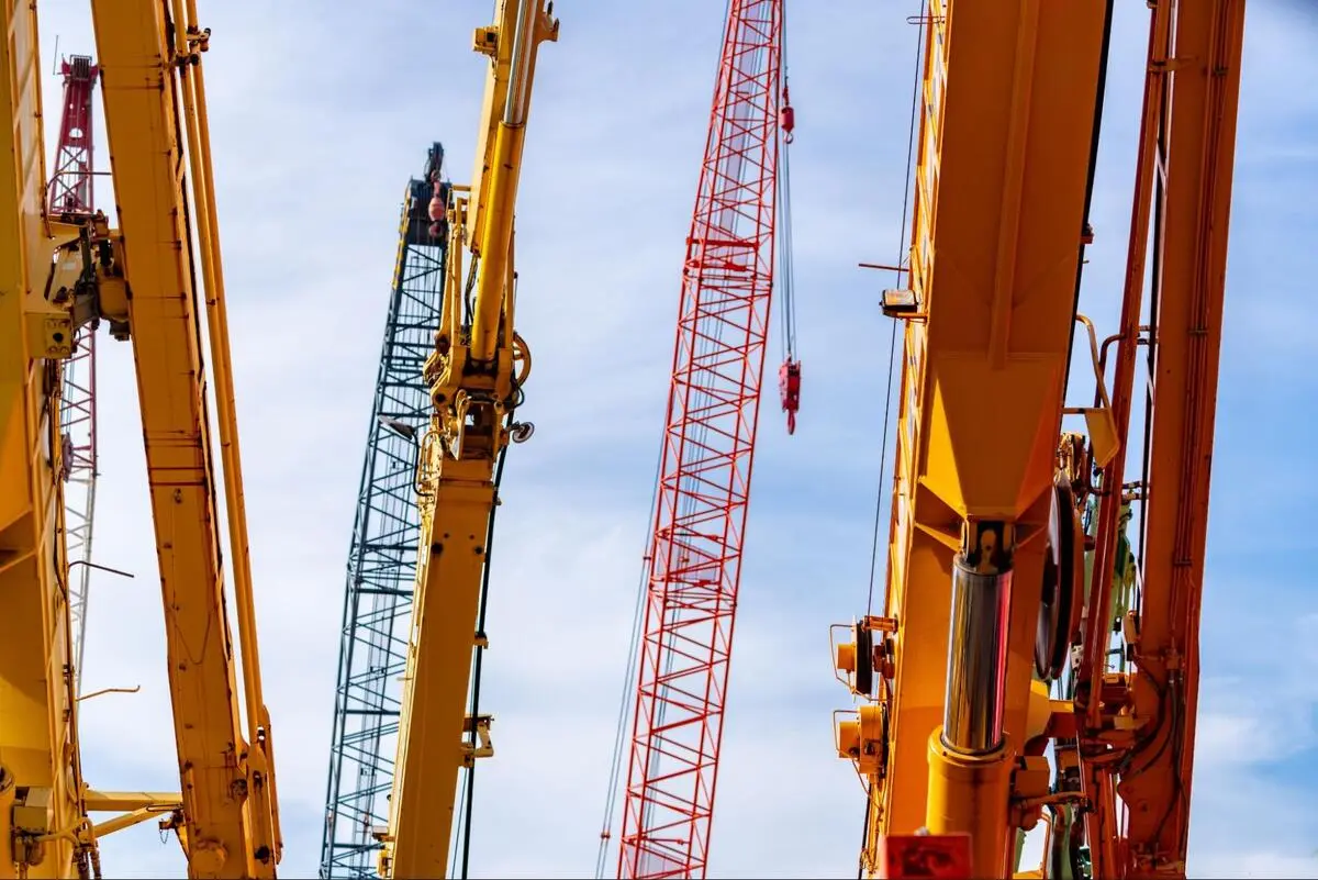 OEM Crane Parts Documentation for Crawler Crane Crawler crane boom extended against a clear blue sky, representing lifting equipment requiring documented OEM spare part replacements