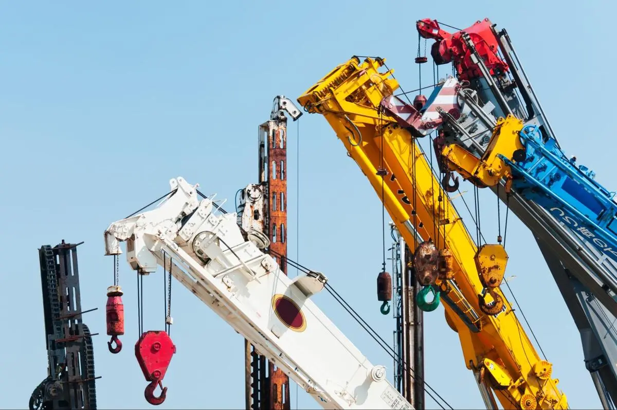 Mobile Crane Fleet Crane Maintenance Records Fleet of mobile cranes with hook and pulley assemblies at an industrial lifting site